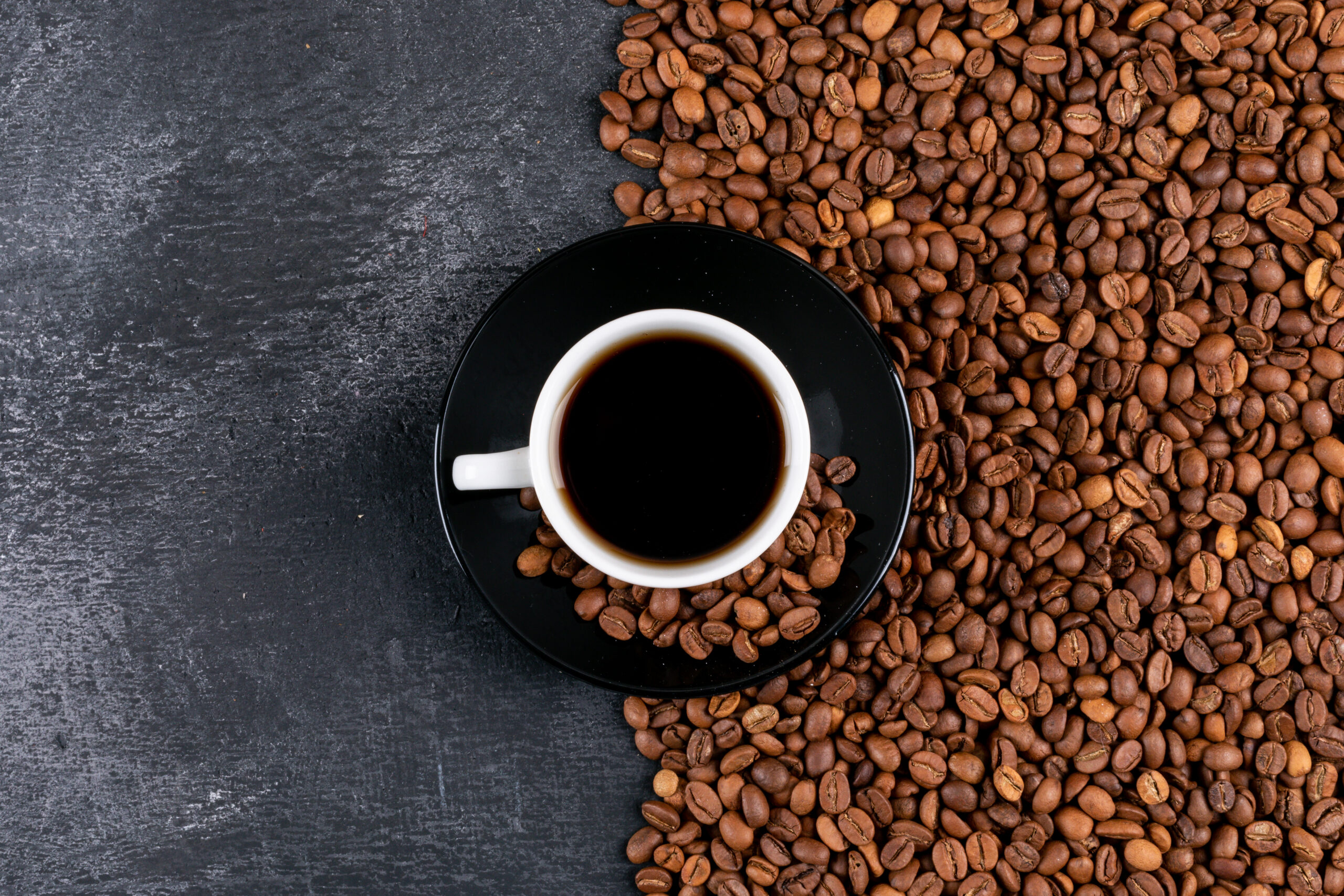 top view coffee cup and coffee beans on dark table